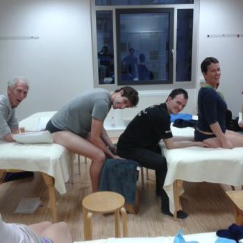 Honoring Harvey Burns Harvey Burns teaching a Rolfing class to students, smiling and engaged.